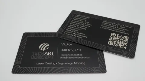 Custom fiber laser engraved black anodized aluminum business cards for TechArt Concept, showing high-precision marking of QR codes and detailed service lists on metal.
